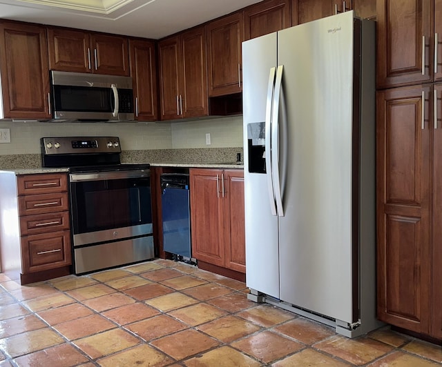 kitchen with tasteful backsplash, appliances with stainless steel finishes, and light stone counters