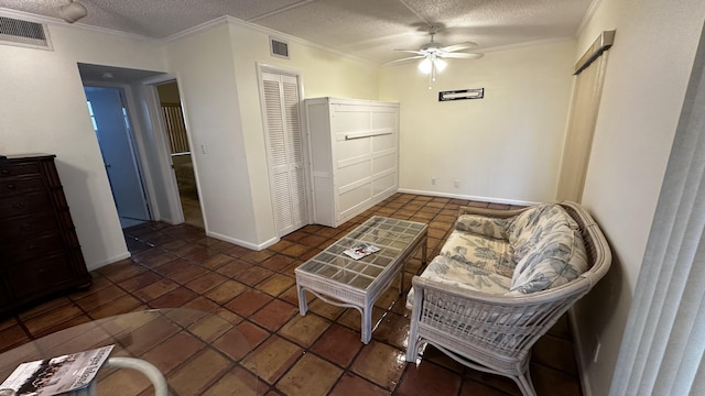 living area with visible vents, a textured ceiling, a ceiling fan, and ornamental molding