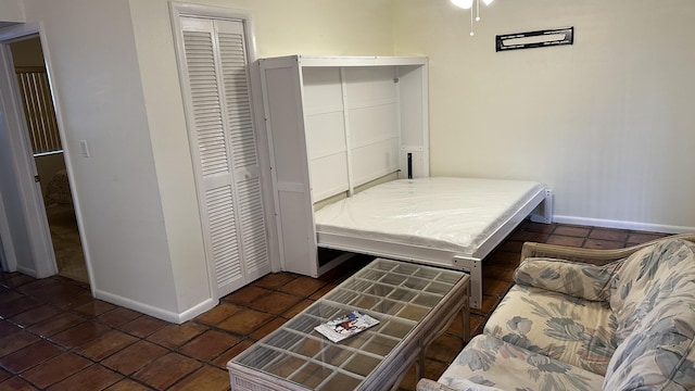 bedroom with a closet, tile patterned flooring, and baseboards