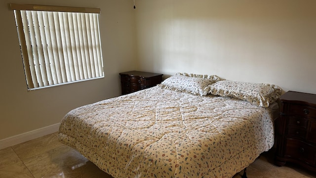 bedroom featuring tile patterned floors and baseboards