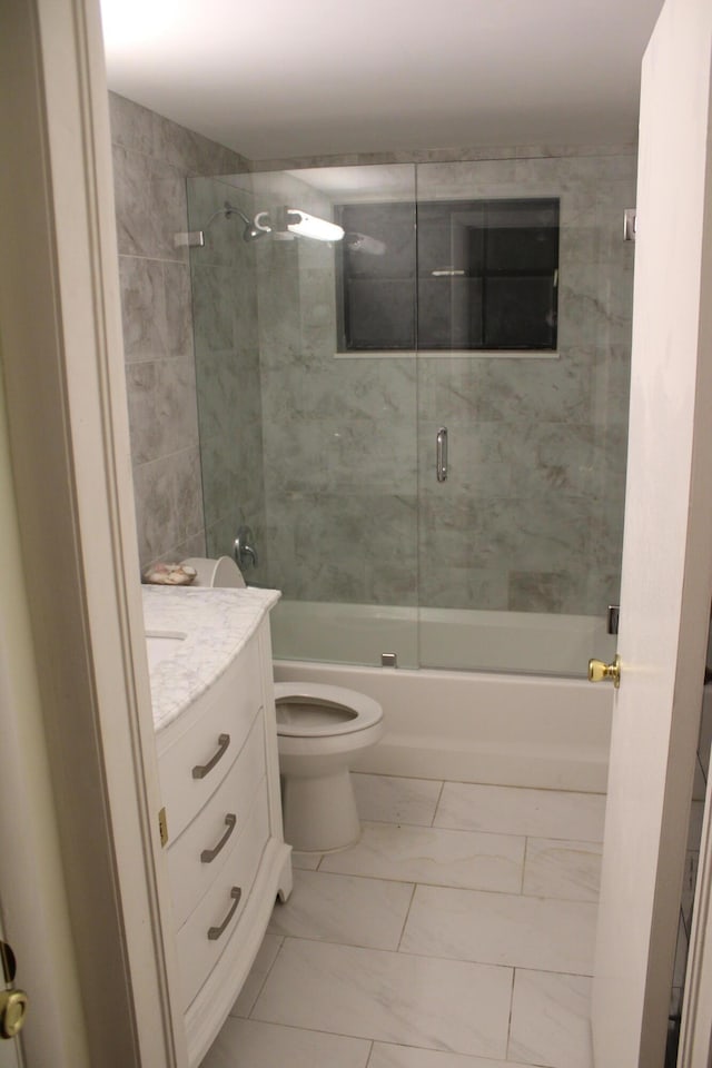 bathroom featuring vanity, toilet, marble finish floor, and shower / bath combination with glass door