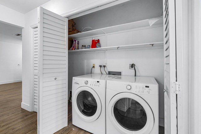 clothes washing area with dark wood-type flooring and washer and clothes dryer