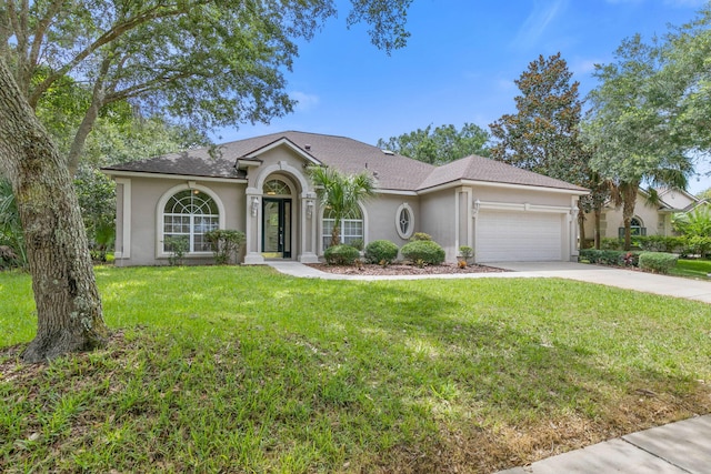 single story home with a garage and a front lawn