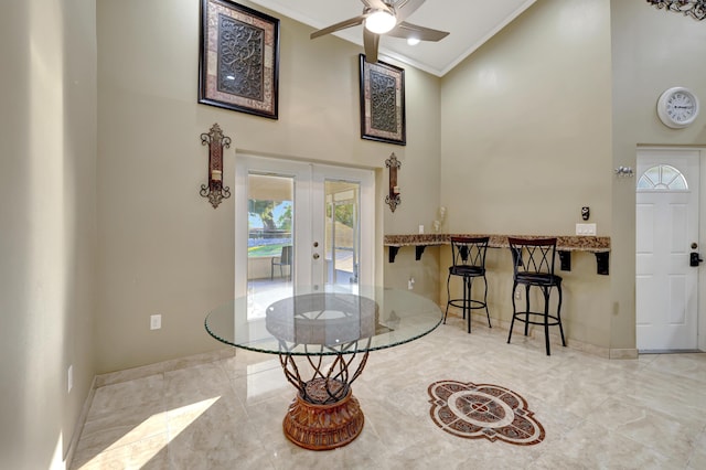 entryway with crown molding, ceiling fan, high vaulted ceiling, and french doors