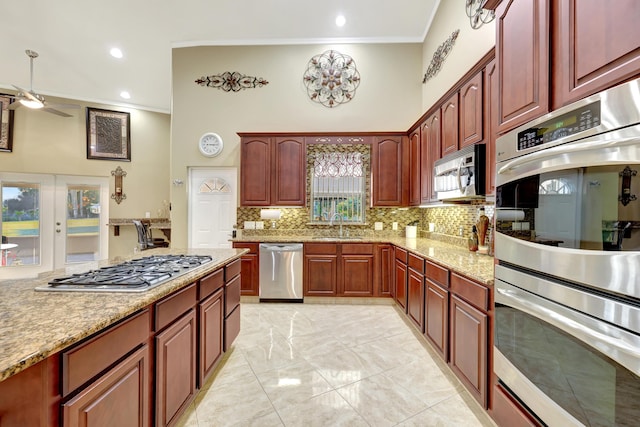 kitchen with ornamental molding, appliances with stainless steel finishes, backsplash, and french doors