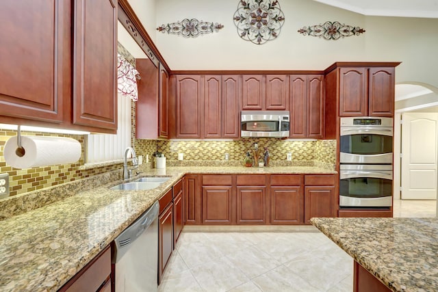 kitchen featuring sink, crown molding, tasteful backsplash, stainless steel appliances, and light stone countertops