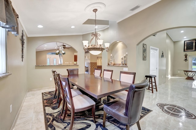 tiled dining area featuring ornamental molding and ceiling fan with notable chandelier