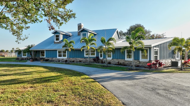 view of front facade with a front yard and central air condition unit