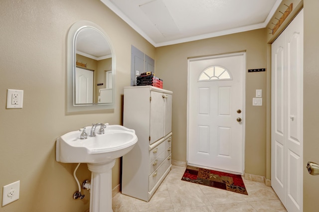 bathroom with ornamental molding, sink, and tile patterned flooring