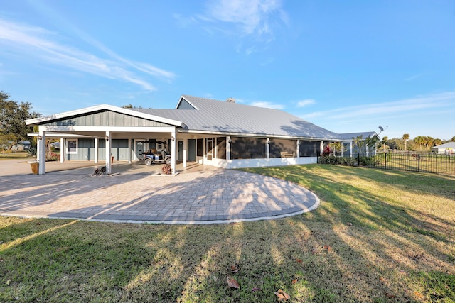 rear view of house with a patio, a sunroom, and a lawn