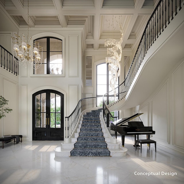 entrance foyer featuring crown molding, a notable chandelier, a towering ceiling, and french doors