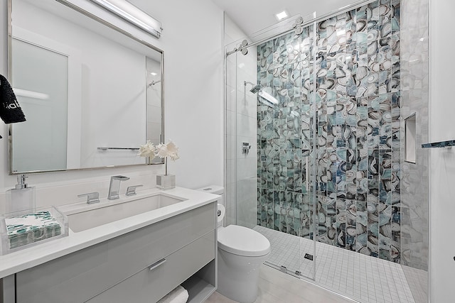 bathroom featuring vanity, toilet, and a shower with door