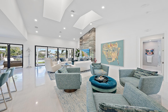 living room with a skylight and high vaulted ceiling