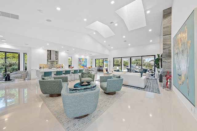 living room featuring high vaulted ceiling and a skylight