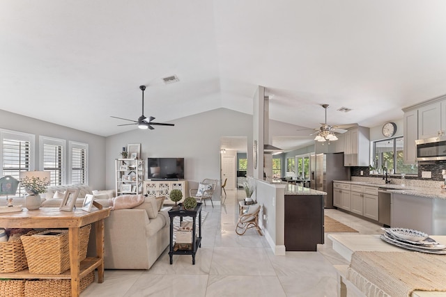 living room with vaulted ceiling, ceiling fan, and sink