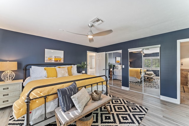 bedroom with multiple closets, ceiling fan, connected bathroom, and light wood-type flooring