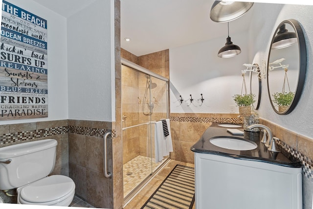 bathroom featuring radiator, tile walls, vanity, an enclosed shower, and toilet