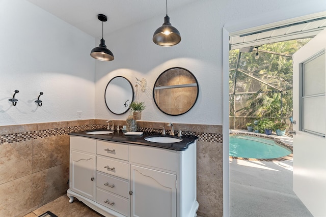 bathroom featuring vanity and tile walls