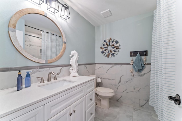 bathroom with walk in shower, vanity, toilet, and tile walls