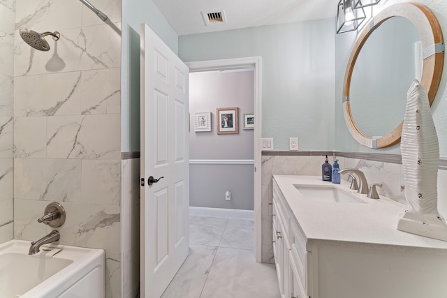 bathroom with vanity, tile walls, and washtub / shower combination