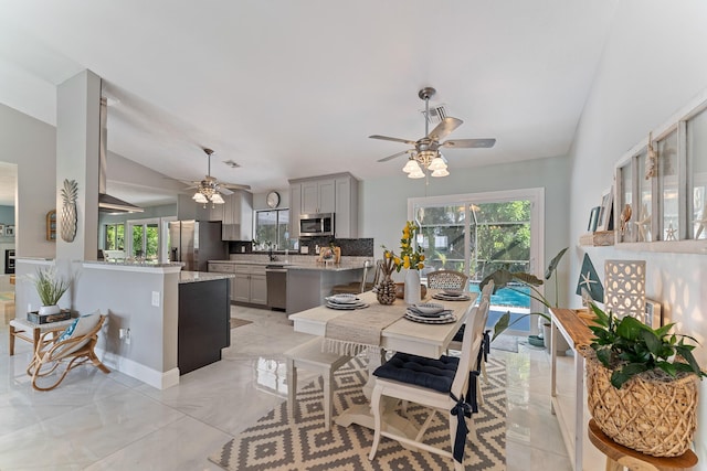 dining area with lofted ceiling, sink, and ceiling fan