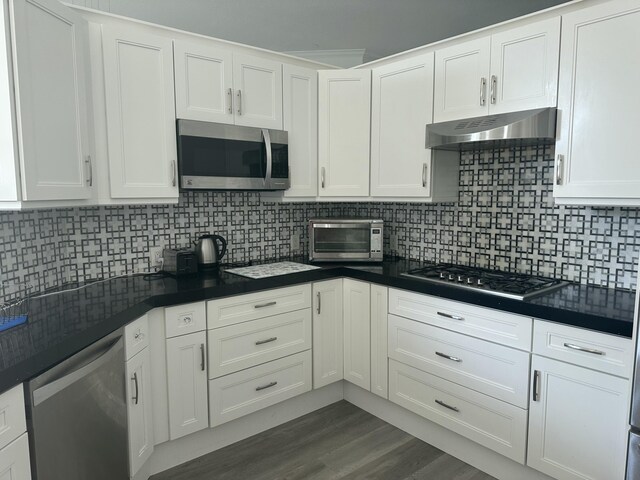 kitchen with white cabinetry, backsplash, and stainless steel appliances