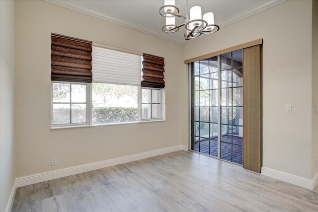 empty room with baseboards, a notable chandelier, ornamental molding, and wood finished floors