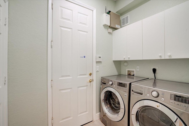 laundry area with visible vents, a textured wall, independent washer and dryer, and cabinet space