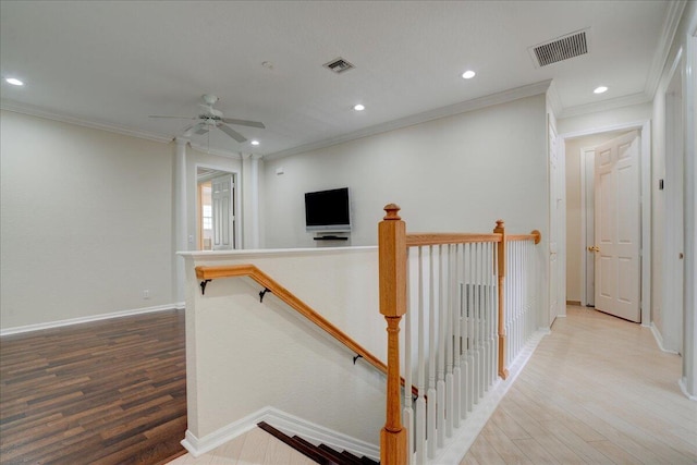 hall featuring baseboards, visible vents, an upstairs landing, and wood finished floors