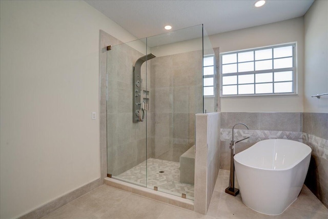 bathroom with a soaking tub, tile patterned flooring, a tile shower, and recessed lighting