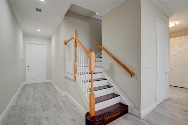 stairs with hardwood / wood-style flooring and ornamental molding