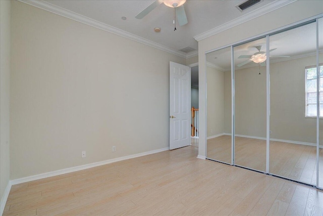 unfurnished bedroom with ornamental molding, visible vents, baseboards, and wood finished floors