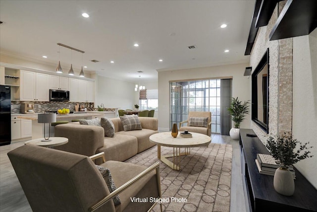 living room featuring light wood-type flooring, visible vents, crown molding, and recessed lighting