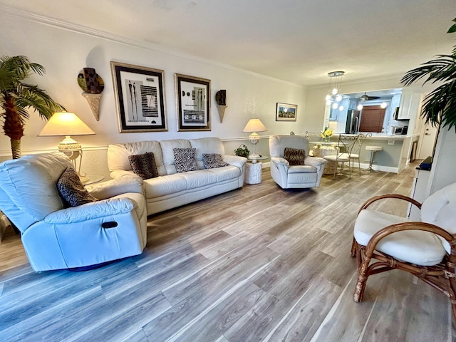 living room with ornamental molding and light hardwood / wood-style floors