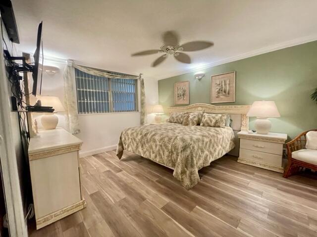 bedroom featuring ornamental molding, ceiling fan, and light hardwood / wood-style floors