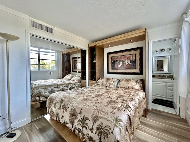 bedroom with hardwood / wood-style flooring, ornamental molding, and a closet