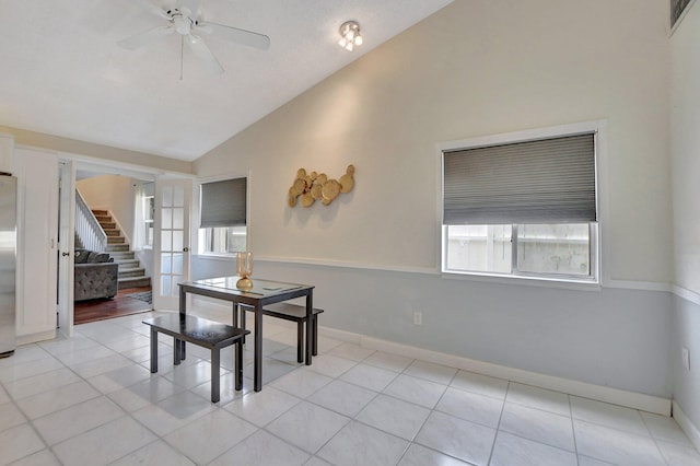 dining area with stairs, vaulted ceiling, and light tile patterned floors