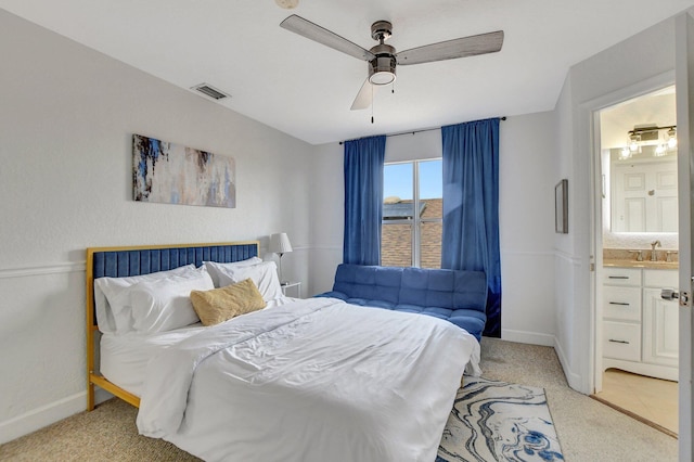 bedroom with baseboards, visible vents, a ceiling fan, light colored carpet, and a sink