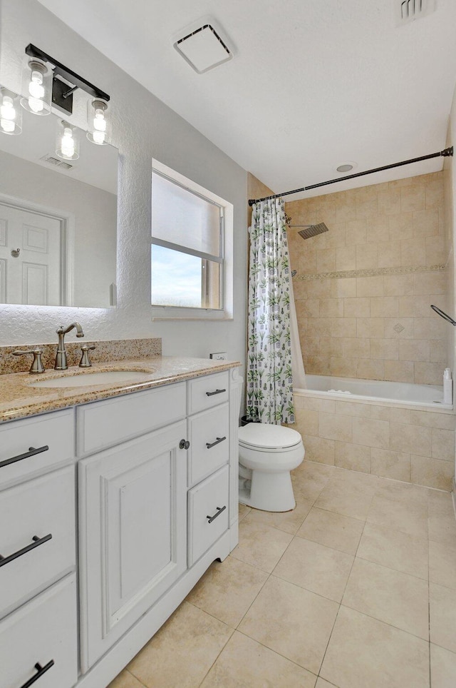 bathroom with tiled shower / bath, visible vents, toilet, vanity, and tile patterned floors