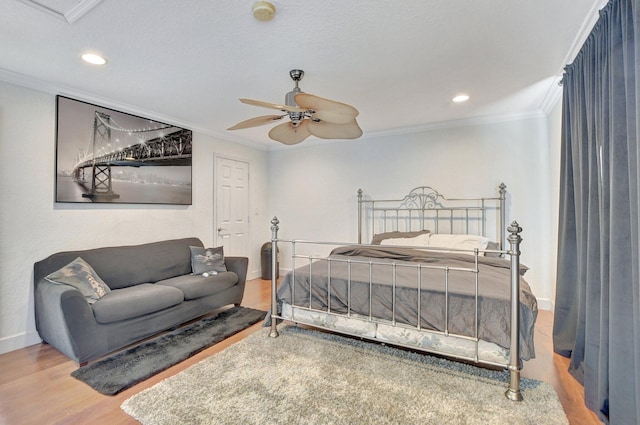 bedroom with ornamental molding, wood finished floors, and baseboards