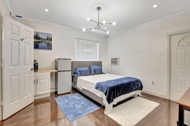 bedroom with freestanding refrigerator, a wall unit AC, crown molding, and wood finished floors