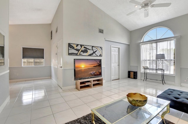 living room with a textured ceiling, tile patterned flooring, visible vents, and a ceiling fan