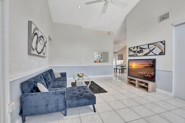 tiled living room with a ceiling fan, visible vents, high vaulted ceiling, and baseboards