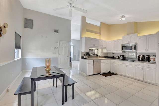 kitchen featuring light tile patterned floors, visible vents, dark countertops, stainless steel appliances, and white cabinetry