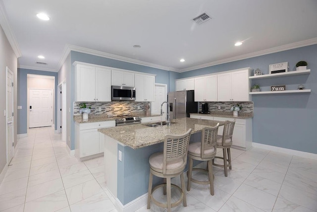 kitchen featuring white cabinetry, appliances with stainless steel finishes, sink, and a center island with sink