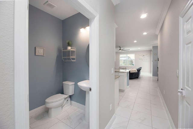 bathroom featuring ceiling fan, ornamental molding, and toilet