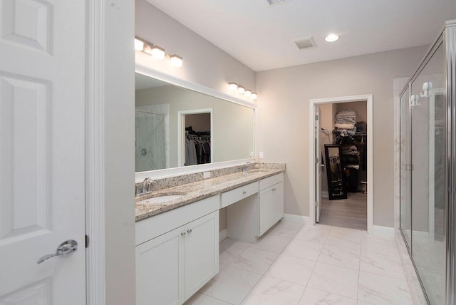 bathroom with vanity and a shower with door