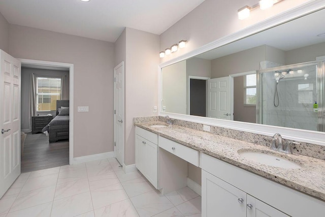 bathroom with vanity and a shower with door