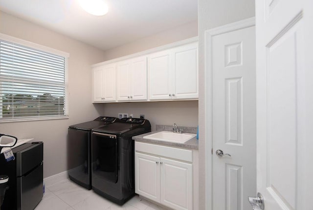 clothes washing area with cabinets, sink, and washing machine and clothes dryer