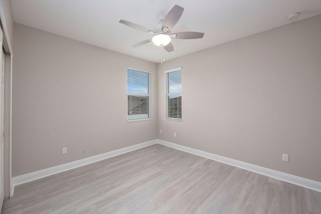 empty room with ceiling fan and light hardwood / wood-style flooring